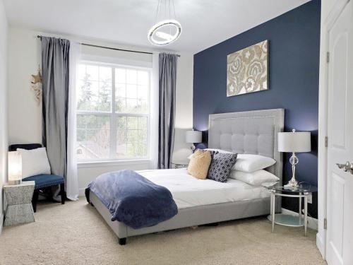 a bedroom with a bed with blue walls and a window at Eaglemont Golf Course Peaceful Retreat in Mount Vernon