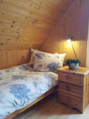une chambre avec un lit et une table de chevet avec une lampe dans l'établissement Rugsund Handelsstad, à Rugsund