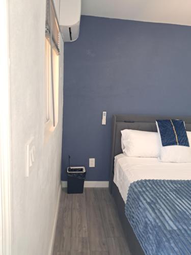 a bedroom with a bed and a blue wall at Small's Cozy Rest 6 Efficiency 