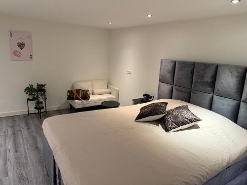 une chambre avec un grand lit et une chaise dans l'établissement Woonhuis 170m2 Rotterdam Centrum, à Rotterdam