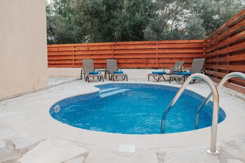 a swimming pool with chairs in a backyard at Villa Aphrodite in Paradise Gardens - 3bd with Private Pool by VICHY Holidays in Nea Paphos