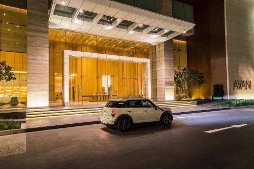 a white car parked in front of a building at Avani Plus Riverside Bangkok Hotel in Bangkok