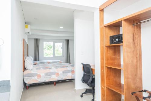 a bedroom with a bed and a desk at Suites Gaby Cancun in Cancún