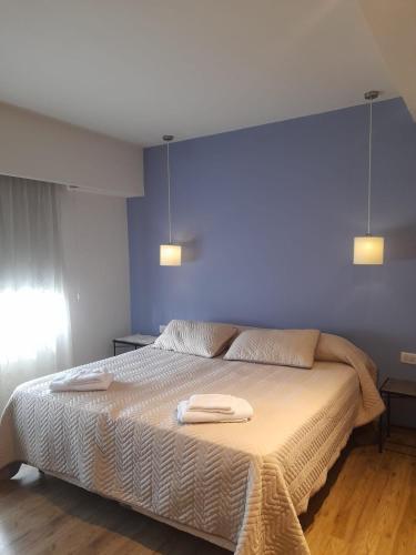 a bedroom with a large bed with two towels on it at Casa con encanto serrano in Villa General Belgrano