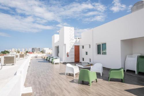 a balcony with chairs and tables on a building at Suites Gaby Cancun in Cancún