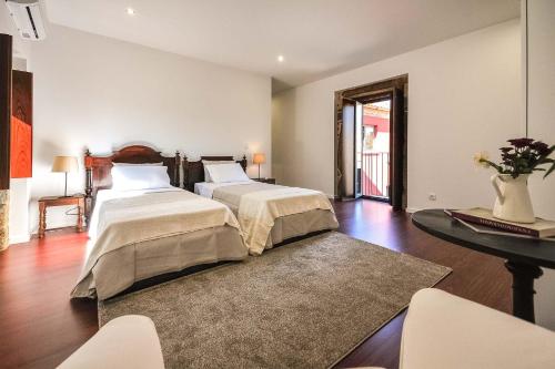 - une chambre avec 2 lits et une table avec des chaises dans l'établissement Villa Mit Viel Platz Und Pool In Vila Cova, à Gemezes