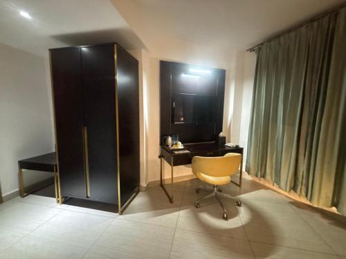 una habitación con un escritorio, una silla y un armario en FOPROLUX Palace, en Douala