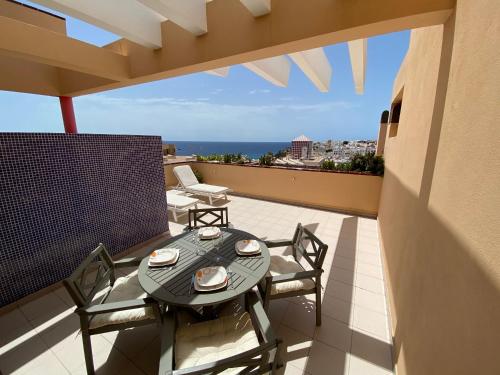 a patio with a table and chairs on a balcony at Tajinaste Sol in Morro del Jable