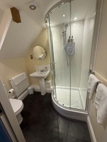 a bathroom with a shower and a toilet and a sink at The Windmill Inn in Collingham