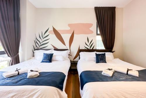 ein Zimmer mit zwei Einzelbetten, auf denen Schuhe stehen in der Unterkunft Luxury Villa Kristal Seksyen 7, Shah Alam - Smarthome in Shah Alam
