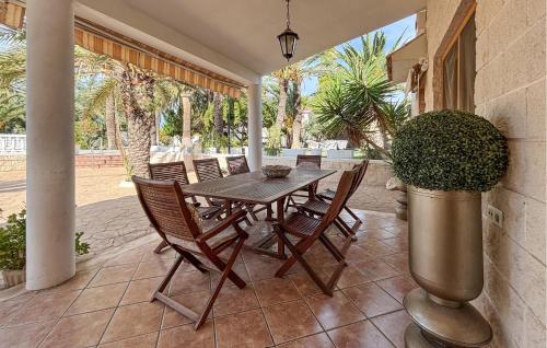 a wooden table and chairs on a patio at Pet Friendly Home In Elda in Almafrá