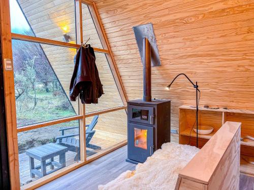 a room with a wood stove in a cabin at OUTSCAPE I Estero I Wifi I Escalada I Cerro Castillo in Villa Cerro Castillo