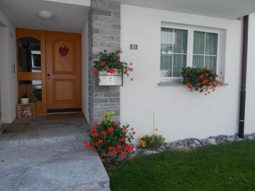 ein Haus mit zwei Blumenkästen an der Seite in der Unterkunft Ferienwohnung für 2 - 5 Personen mit zwei getrennten Schlafzimmern in Saas-Almagell