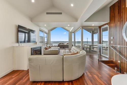 a living room with a couch and a fireplace at Aloha Beachfront Port Fairy in Port Fairy