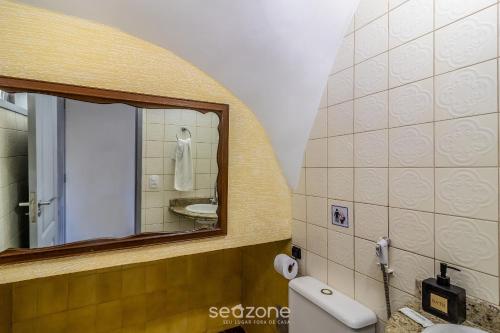 une salle de bain avec un miroir et un lavabo dans l'établissement Casa em Cabo Frio a 200m da praia ADP001, à Peró