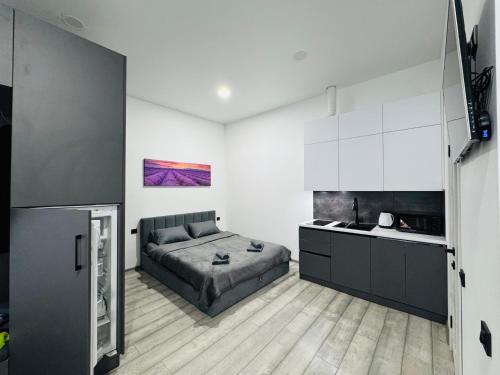 1 dormitorio con 1 cama y cocina. en Studio Apartment центр міста Чернівці, en Chernivtsi