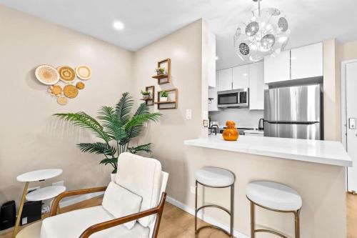 eine Küche mit einer weißen Theke und Stühlen in der Unterkunft Peaceful Modern HNL Getaway in Honolulu