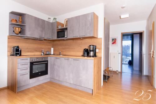 a kitchen with stainless steel appliances and wooden cabinets at Appartement Mit Balkon in Bad Koetzting
