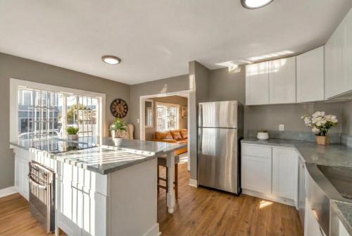 une cuisine avec des armoires blanches et un réfrigérateur en acier inoxydable dans l'établissement Urban Haven in Oakland with Easy Transit, à Oakland