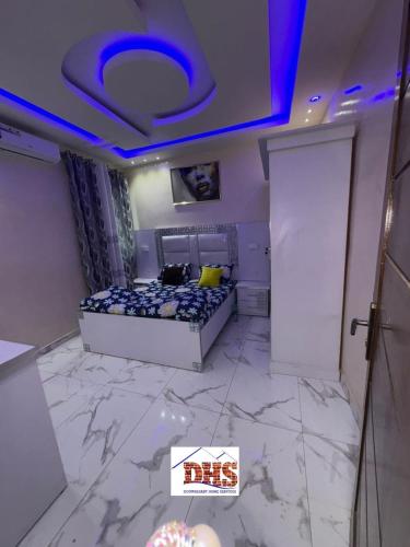 a bedroom with a bed and a blue ceiling at DHSimmo Cozy home in Rufisque