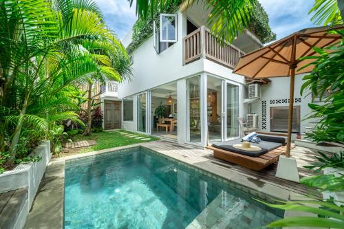 a villa with a swimming pool and a house at Yume Villas in Uluwatu