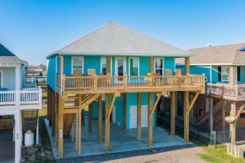 une grande maison bleue avec une terrasse sur le toit dans l'établissement Salty Sunrise home, à Crystal Beach