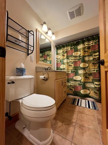 a bathroom with a toilet and a wallpaper with food at CAL56Left in Alton