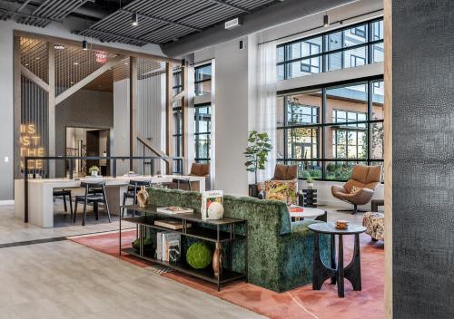 a lobby with a couch and tables and chairs at Hyatus Luxury Residences Boston Everett Signature Collection in Everett
