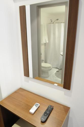 a mirror on top of a table with a remote control at Hotel California in Montevideo
