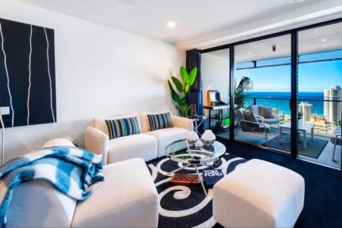 a living room with white furniture and a view of the ocean at Sea-view apartment in the heart of Gold Coast in Gold Coast