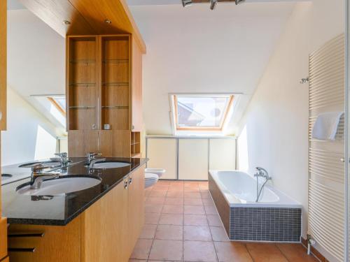 a bathroom with a sink and a tub and a toilet at Penthouse in Uitgeest