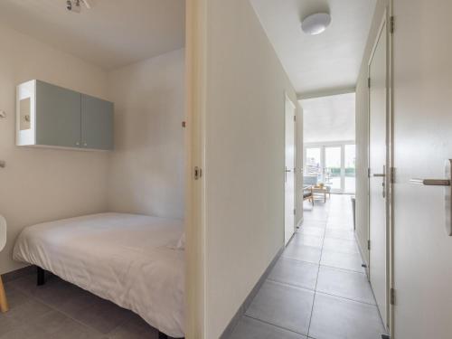 a small bedroom with a bed and a hallway at Waterfront in Uitgeest