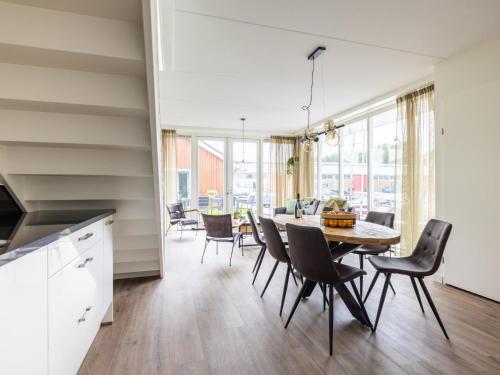 a kitchen and dining room with a table and chairs at Lakehouse I in Uitgeest