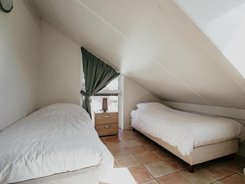 a bedroom with two beds and a window at Busch en Dam in Uitgeest