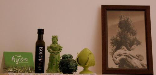 a table with a bottle of wine and a picture at Home Holiday Salento Casa Agrosì in Supersano