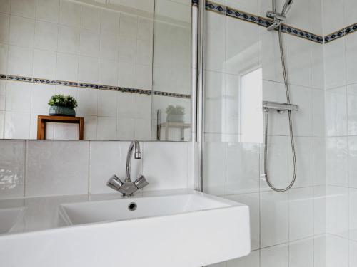 a white bathroom with a sink and a shower at Oostergeest in Uitgeest