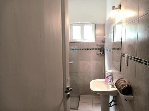 Un baño blanco con lavabo y ducha. en Belen, en San Rafael