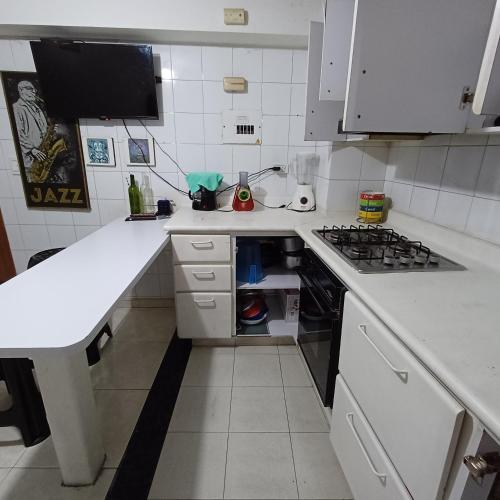 eine kleine weiße Küche mit einem Herd mit Backofen in der Unterkunft Quédate En El Punto Más Central De Manizales in Manizales