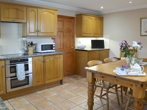 a kitchen with wooden cabinets and a wooden table at Ferguson in Warenford