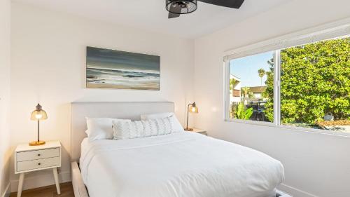 圣克莱门特Steps to Beach Hot Tub Private Patio 259 Trailhead Trestles 3 by AvantStay的一间卧室，有一张白色的床和一扇窗户