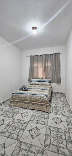 a bedroom with a bed and a tiled floor at casa da Cilene in Ilha Grande