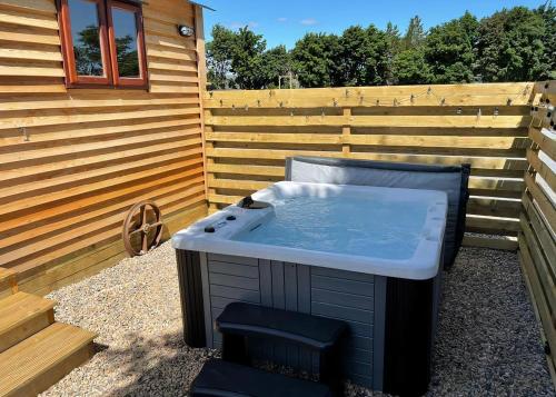 a hot tub in a backyard next to a fence at Bainbridge Ings in Hawes