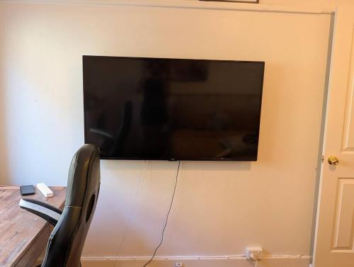 Un televisor de pantalla plana colgado en una pared en Home in Leichhardt, Sydney, en Sídney