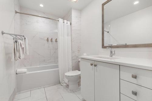 um banheiro branco com um vaso sanitário e uma pia em The Saddlery - Showroom - Walk to Broadway em Nashville