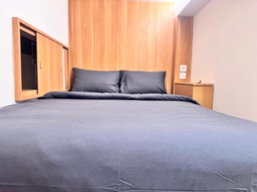 a bedroom with a large bed with a wooden headboard at Althia Capsule Quarters in Badung