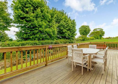 a wooden deck with a table and chairs on it at Durham Coastal Lodges in Haswell