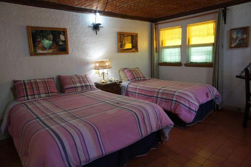 ein Schlafzimmer mit zwei Betten in einem Zimmer in der Unterkunft Suites Poza Real in Tequisquiapan