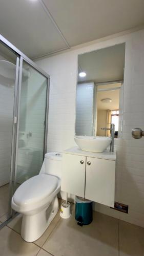 a bathroom with a toilet and a sink and a mirror at Habitación Matrimonial en el centro de la ciudad in Ayacucho