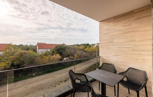 a patio with a table and chairs on a balcony at Beautiful Home In Vir in Kaštelina