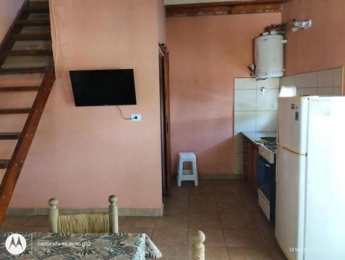 een keuken met een witte koelkast en een trap bij Duplex Luz de Sol in Las Toninas
